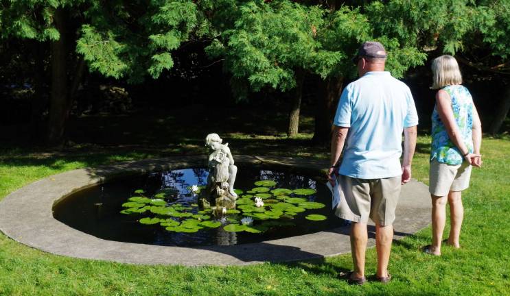 Visitors are shown admiring one of the numerous fountains at Meadowburn Farm.