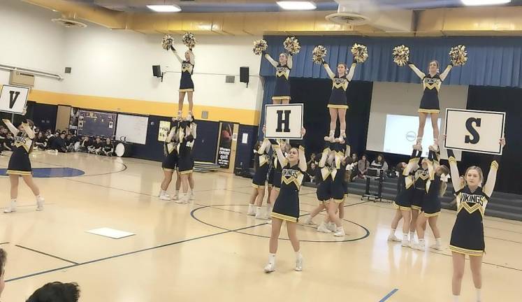 The cheer team performs sideline cheer.