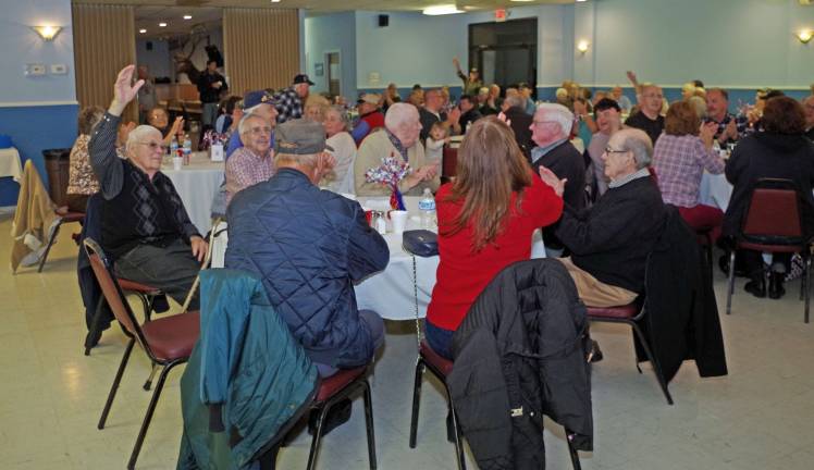 Veterans raise their hands as their branch of military service is announced.