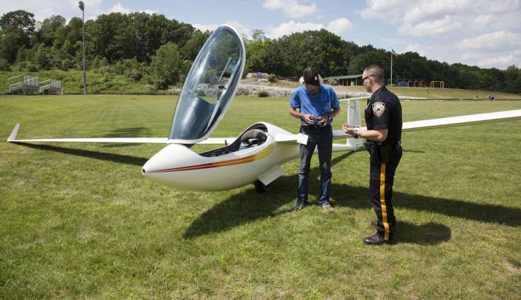 Photo by Robert G. Breese Vernon police speak with glider pilot Charles Mampe of Ringwood, who was forced to land his aircraft at Maple Grange Community Park in Vernon at about 2:30 p.m. Friday.