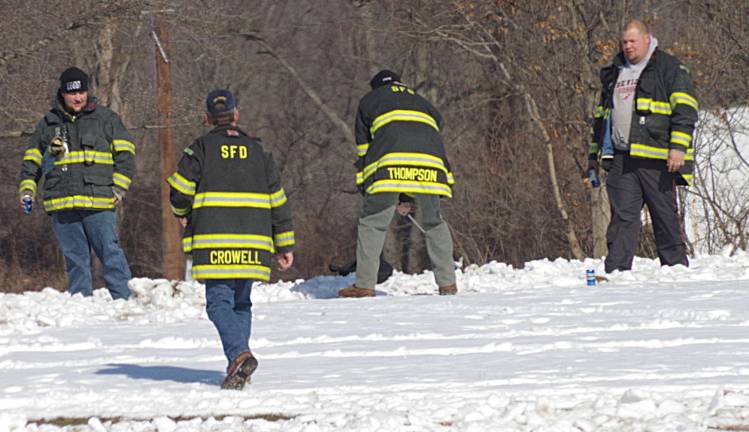Harry Thompson (third from left) prepares for a chip shot through the snow as fellow Sussex Borough firefighters Chris Ross, Rich Crowell, and Scott Theobold look on.