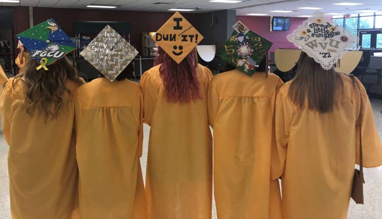 Vernon Township High School seniors show off the decorations on their graduation caps.