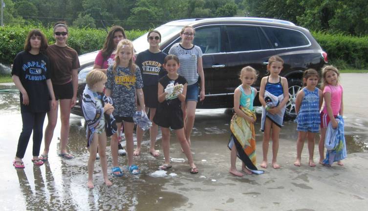 PHOTOS BY JANET REDYKE The Vernon Girls Softball League take a break from diligently washing cars at their Saturday June 2 car wash.
