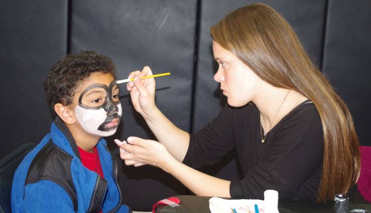 Jayden Benoski-Bowen, 7, had his face painted by freshman Pea Brich, 15 during the event.