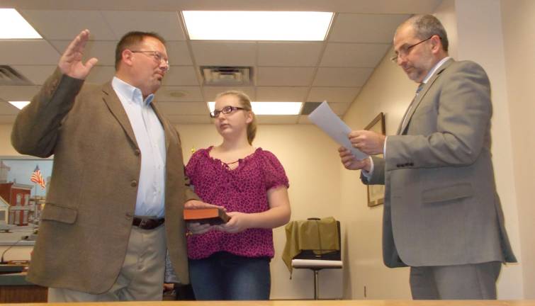 Photos by Vera Olinski Sussex Borough Councilman Robert Holowach is sworn in by Municipal Court Mark Zschack as his daughter hold Emily looks on.