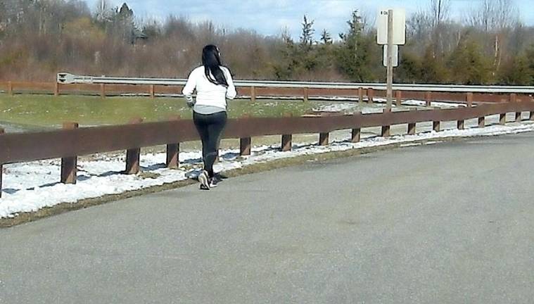 A lone jogger works out on Sunday at Maple Grange Park after a snowy Saturday left only about an inch to two inches of the white stuff.