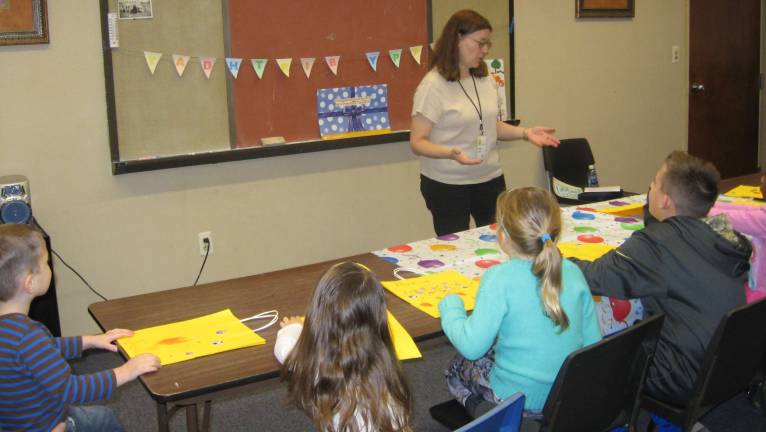 Party organizer Cindy Lynch discusses the story of Christmas with the youngsters.