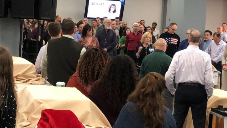 Deborah Berry-Toon, executive director of Project Self-Sufficiency, speaks to the Selective Insurance employees before they start assembling bikes for the Season of Hope Toy Shop.