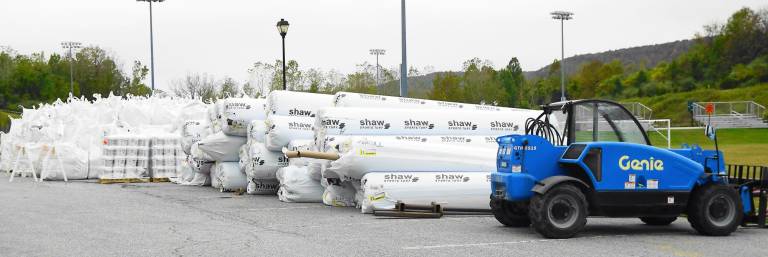 Bags of crystalized rubber and rolls of Astro-turf wait to be placed on the Maple Grange fields