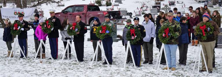 Members of the armed services hold remembrance wreaths in honor of each military branch.