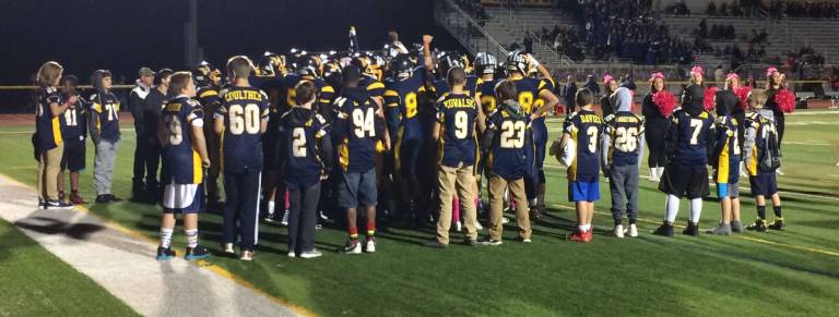 Midget and Pee-Wee Vernon Youth Football players surround Varsity football team as they enter the field for this past Friday's win over Mount Olive at Macerino Stadium.