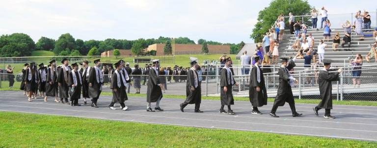 Students progress to Pomp and Circumstance, with cheers. (Photo by Vera Olinsky)