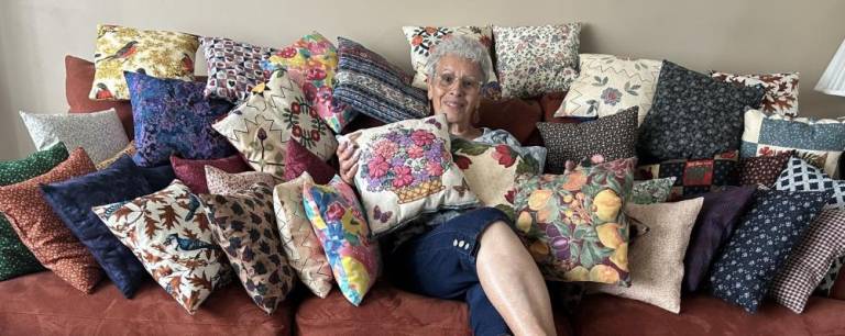 Reba Burrell, a member of the Vernon Township Woman’s Club, shows off the dozens of pillows she made for patients at Newton Medical Center.