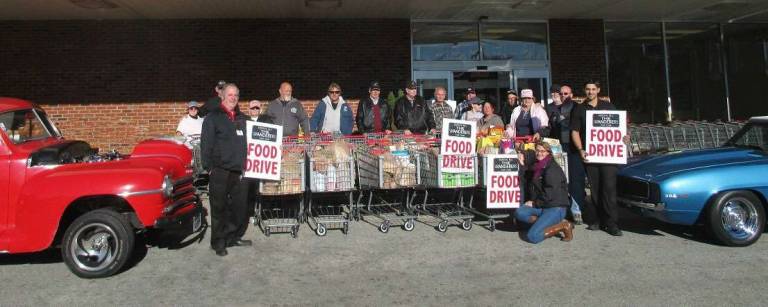 Pictured are members of the Wanderers Car Club with two representatives of Acme Supermarket holding the food-drive signs.