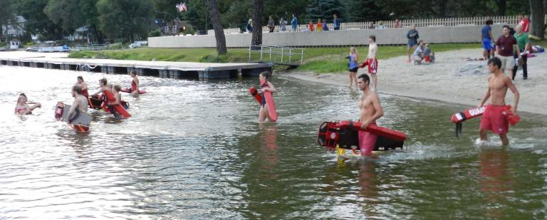 Lifeguards entering the water for the Backboard event.