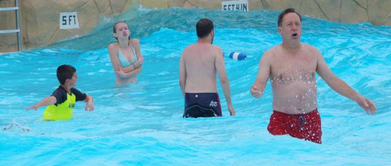 After the pool's wave action machine was activated, some of the adults were enticed to enter the chilly water.