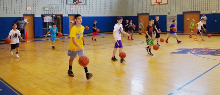 Crossroads Basketball Camp participants practice dribbling the ball.