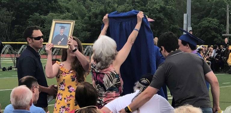 PHOTOS BY ROSEMARY MCGUIREThe family of Vinny Ventriglia, ,who died earier this school year from cancer, holds up his photo and graduation robe.