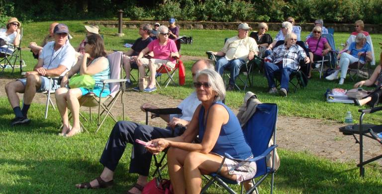 oncert goers enjoy the music on a lovely summer evening.