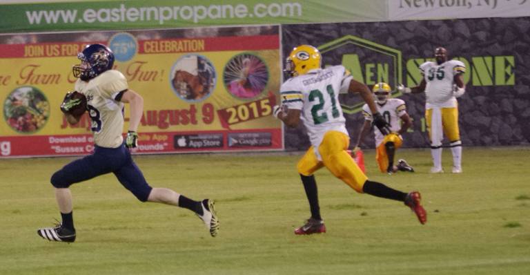 Stags wide receiver Ken Christensen carries the ball while pursued by Green Jackets in the first quarter.