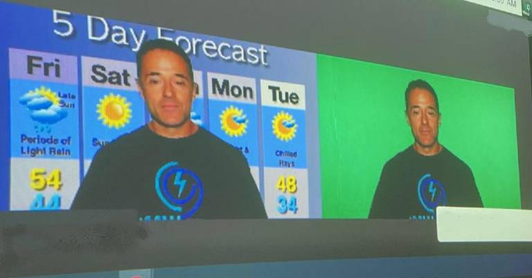 Meteorologist John Marshall demonstrated how green screen technology works to project the weather map behind him while he forecasts the weather on television (Photo provided)