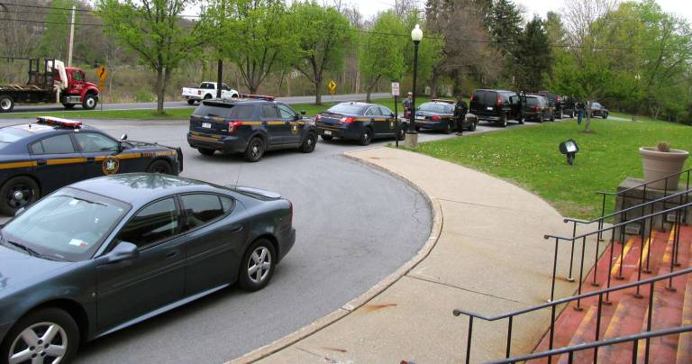 State Police vehicles lined up outside Warwick Town Court Thursday afternoon, bringing more than a dozen suspects for arraignment.