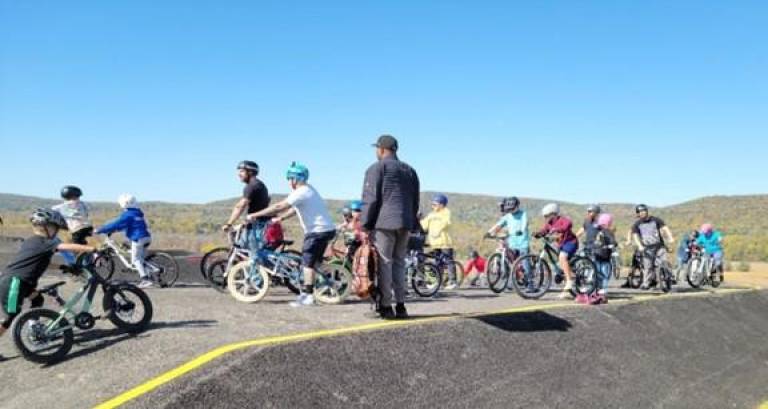 Mayor Howard Burrell watches cyclers take on the new pump track on Saturday during the grand opening.