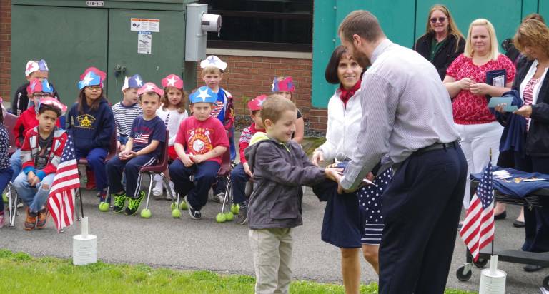 Walnut Ridge students offer patriotic songs for veterans and family members Walnut Ridge student Walter Mentone, 7, is shown presenting his father Chris with a "Dedicated Dads" T-shirt. Chris Mentone was one of dozens of fathers who have been volunteering at the school and who were honored at the sing along.