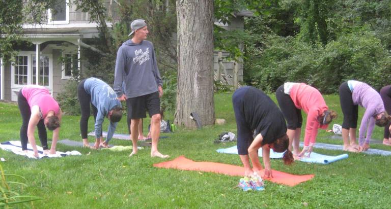 Zach Shortway instructs an outdoor yoga class on Saturday morning on the grounds of the Daily Bean Cafe.