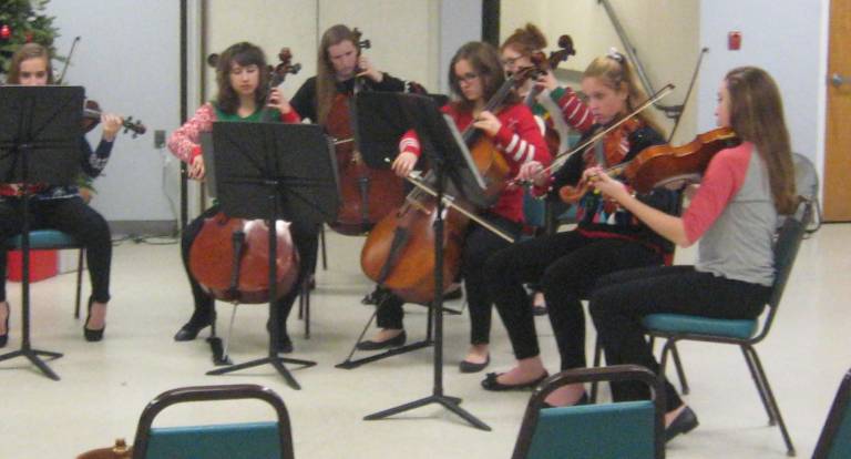 The right section of the orchestra readies to begin the Christmas concert.