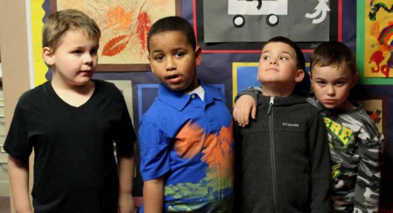 Posing in front of the exhibit on a special visit to the Board of Education office is Jacob, Thomas, Kristian and Juan.