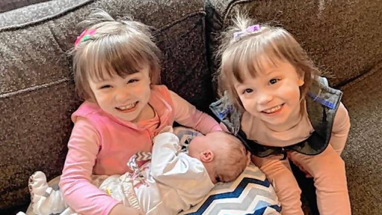 Identical twins Rebekah and Charlotte Smith hold their sister, Sadie, who was born Feb. 29. (Photos provided)