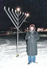 <b>Rabbi Mendel Dubov speaks in front of the Menorah.</b>
