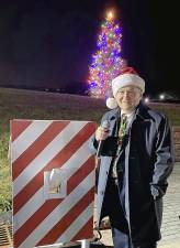 Hardyston Mayor Brian Kaminski with the festive new Christmas tree switch created by DPW director Bob Schultz, and the lighted tree in the background (Photo by Laura J. Marchese)
