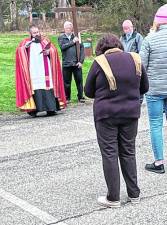 <b>The Rev. Chris Barkhausen, pastor of St. Francis de Sales Church in Vernon, begins the journey of Jesus by beginning the stations of the cross outdoors on the church grounds.</b>