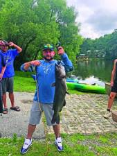 Justin Foglia of Vernon holds a 17-pound catfish, the biggest catch during the fishing contest Saturday, July 8 at Lake Neepaulin Beach in Wantage. (Photos by Greg Smith)