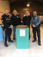 Boxes for donations to the annual Prince of Peace Lutheran Church holiday toy drive are located at the church and at local businesses. From left are Franklin police Sgt. David Schneider; Robert Winter, a church trustee and chairman of the toy drive; the Rev. John Babbitts Jr., the church pastor; and Hardyston Patrolman Ricky Nudo. (Photo by Kathy Shwiff)