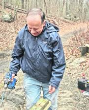 <b>Martin Grossman, president of the Paulinskill Valley Trail Committee, using old wood as a template before drilling into replacement pieces as part of ongoing trail maintenance. </b>