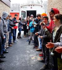 PHOTOS BY VERA OLINSKI Students pass cans in the cold and snow to fill the Sussex County Social Services bus.