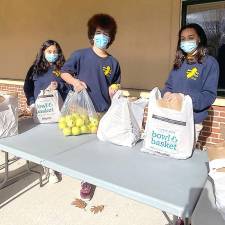 Project Self-Sufficiency volunteers prepare baskets for last year's Thanksgiving donations. (Photo by Laurie Gordon)