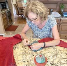 Debra Piccirillo, chair of the club’s Civil Engagement &amp; Outreach Committee, makes one of the stockings sent to Operation Yellow Ribbon in Marlton, N.J. (Photo provided)