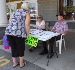 PHOTO BY CHRIS WYMAN On Friday, July 3, Christa and Rob Gerry were still going strong collecting signatures to put the town council&#xfe;&#xc4;&#xf4;s third attempt to give Vernon Mayor Victor Marotta a pay raise on the ballot for the residents to decide. The Gerrys were two of four people in front of the Vernon A&amp;P and two more people were collecting signatures in front of the Highland General Store.