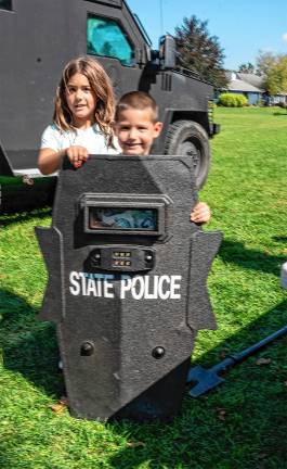 Jay and Riley Olmsted pose behind a New Jersey State Police shield.