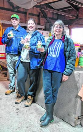 George Butkus, Amanda Lindner and Fran McEnteer hold containers of fresh maple syrup sold at the historic farm.
