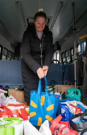 ST1 Rebecca Ismail, a volunteer for the Stuff the Bus campaign against hunger, loads a bus with donated food Friday, Nov. 17 at Lakeland Bank in Sparta. (Photos by Nancy Madacsi)