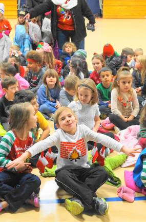 A Kindergarten student shows the sweater his mom made for him.