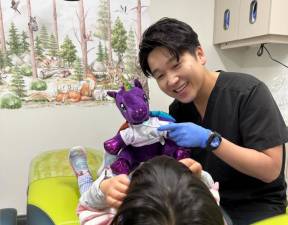 Smile Hero’s Dr. Jackson Jeong uses a stuffed animal to show a patient proper bushing techniques.
