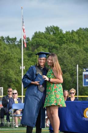 High school staff members were invited to present diplomas to their children. Jen Shirhall gives a diploma to Mason Shirhall.