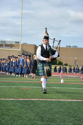 Social studies teacher John Loggie leads the processional with bagpipes; he has been doing this for two decades.
