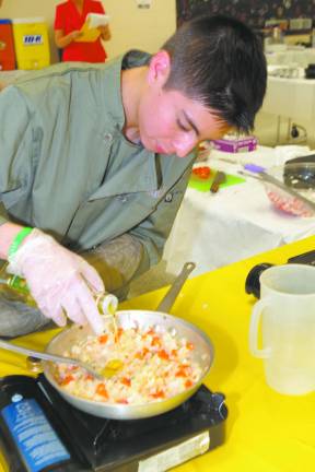 Student chef Jon Soto prepares a sauteed vegetable dish.